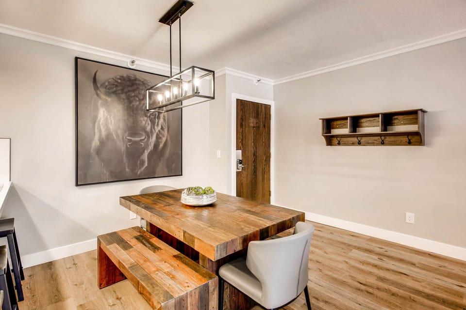 Geometric rectangular pendant chandelier over the dining room table, convenient coat rack upon entrance