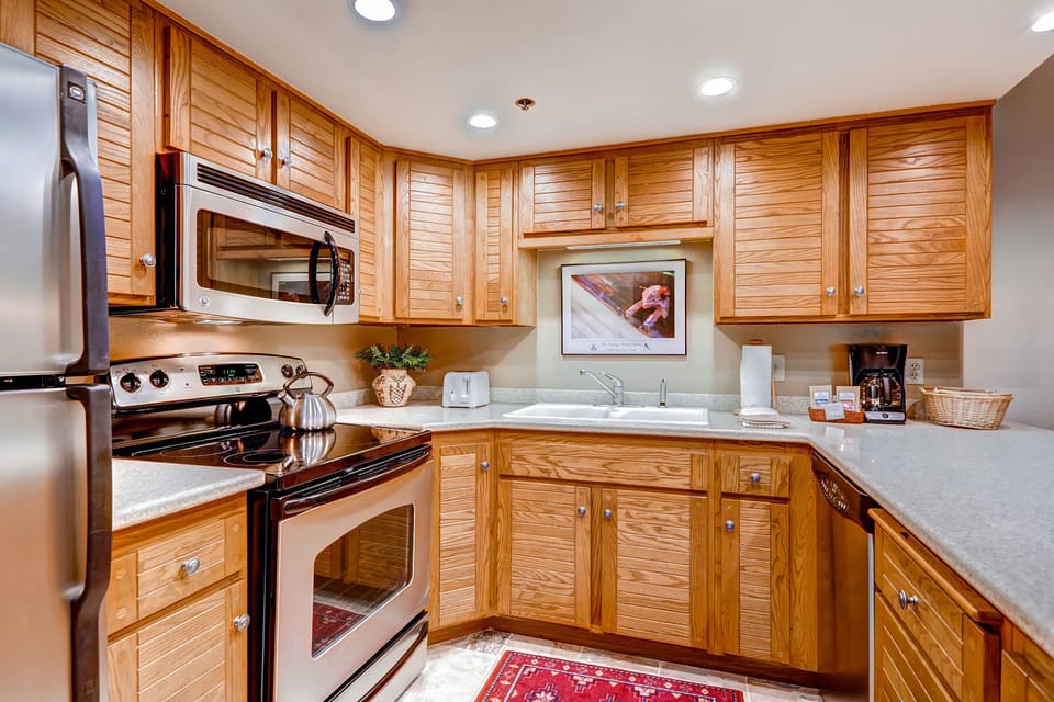The well-equipped kitchen offers stainless steel appliances and wood cabinets.