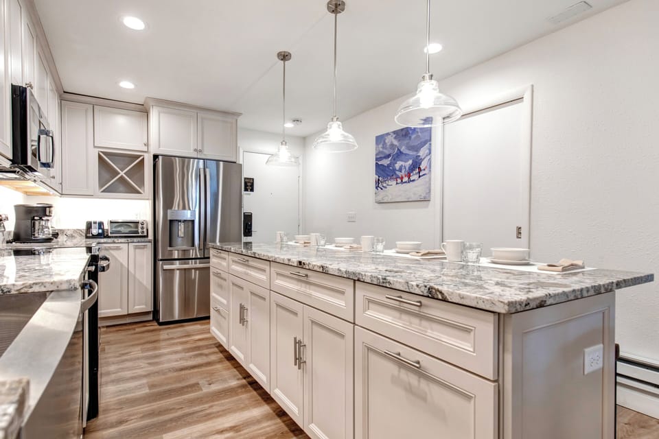 Snow Flower 6 offers a bright kitchen with off white cabinetry, granite counters and spacious island.