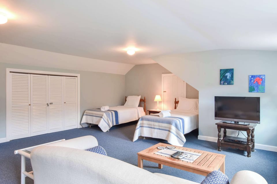2nd Floor Twins Bedroom with a small entertainment area with a couch and TV.