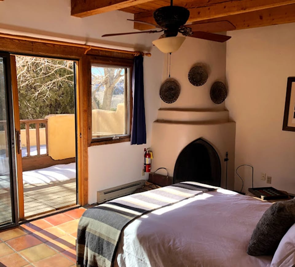 South bedroom with kiva fireplace and roof deck