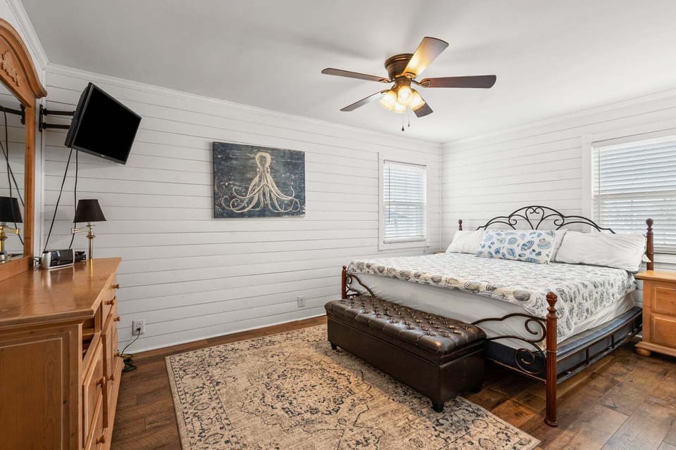 Bedroom with an iron headboard and mounted TV at Dog Days of Summer in Cherry Grove, North Myrtle Beach