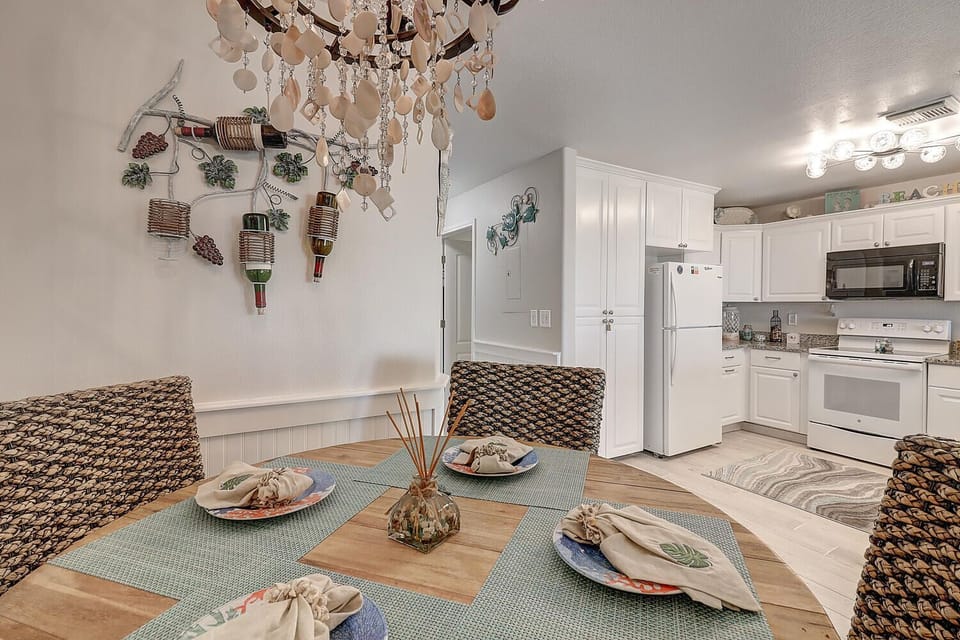 Gather around your beautifully set dining table beneath the elegant chandelier, with your fully-equipped kitchen just steps away for culinary adventures.