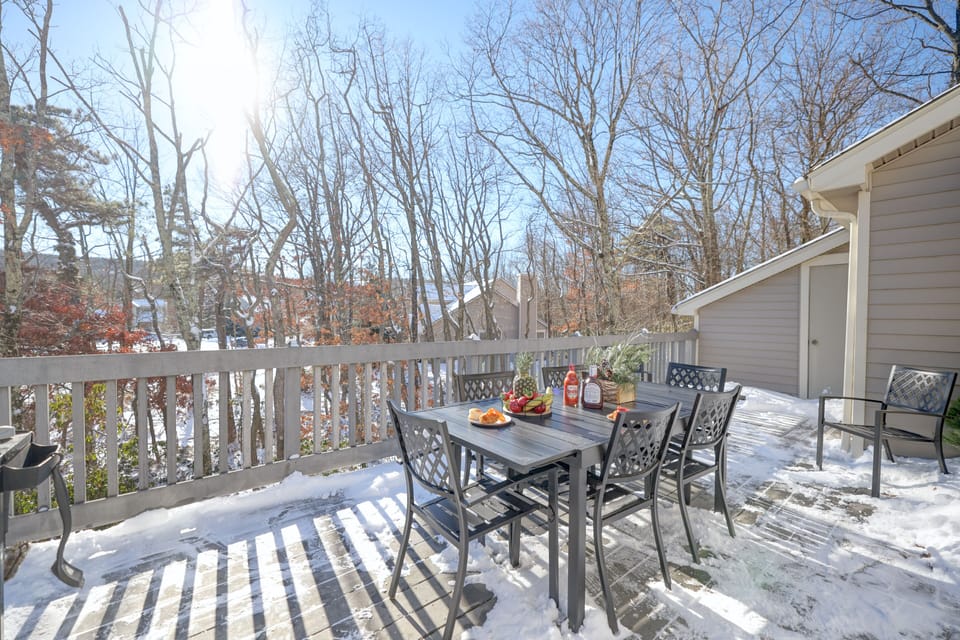 Back deck dining area with a large weber grill with views of ski slopes.