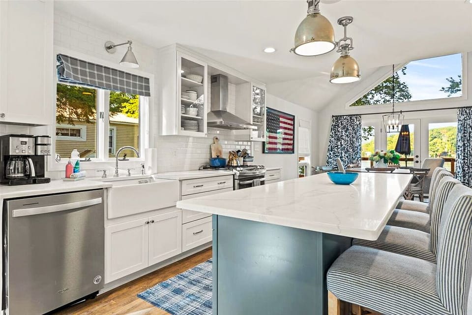 Open-concept kitchen, living room, & dining area with large windows with a view.