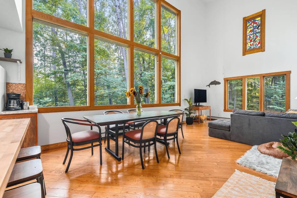 The immense windows in the main living area provide sunlight and a view out into nature, often featuring local deer and foxes.