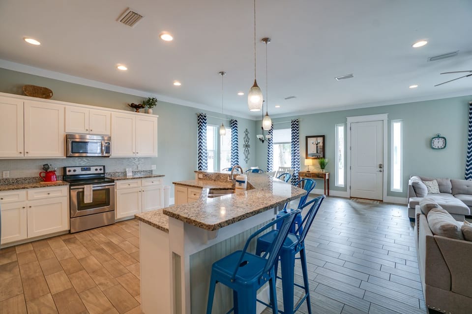Your open-concept kitchen flows seamlessly into the living area, featuring granite countertops, modern appliances, and a breakfast bar perfect for morning coffee.