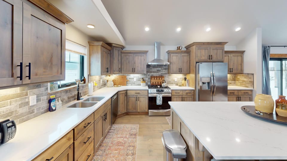 Your gourmet kitchen awaits with gleaming countertops, premium appliances, and warm wood cabinets perfect for creating memorable meals together.