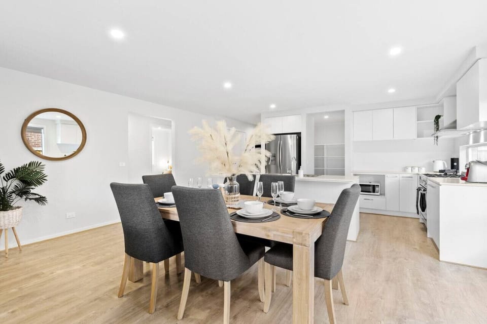 Open-plan dining with a 6-seater modern dining table that leads to the kitchen area.