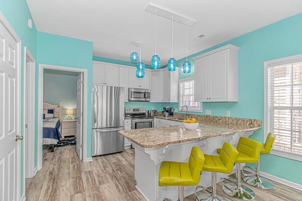Bar stools, breakfast bar, and kitchen.  Master is through door by refrigerator.