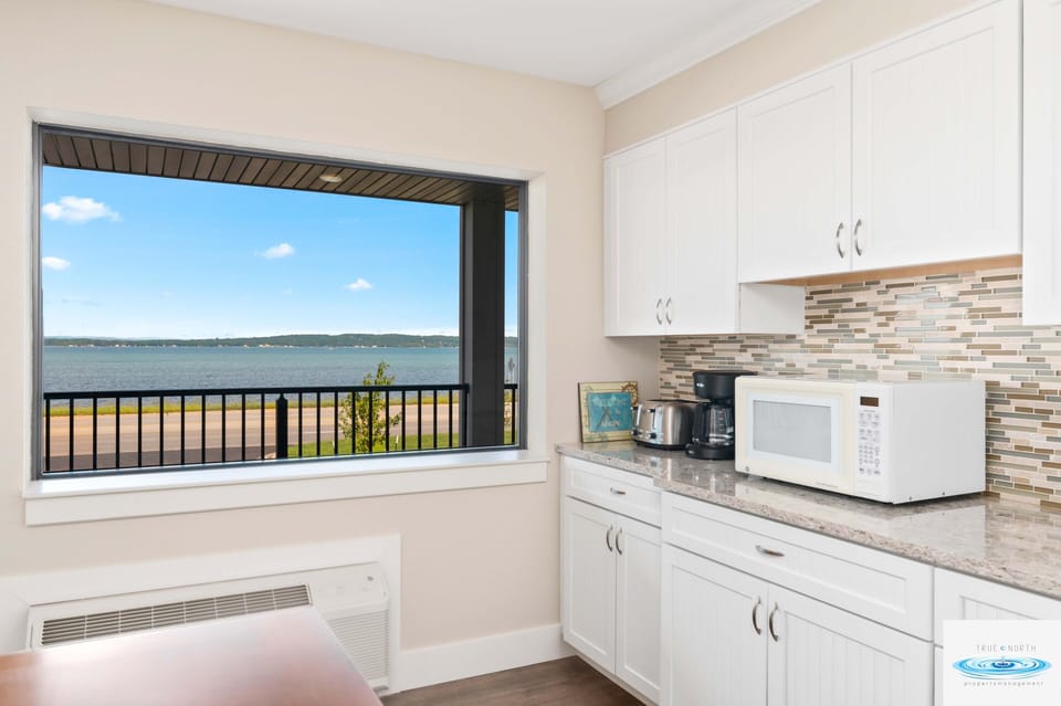 The common area features a well-lit kitchen with essential appliances such as a coffee maker and a microwave, inviting residents to gather and enjoy experiences.