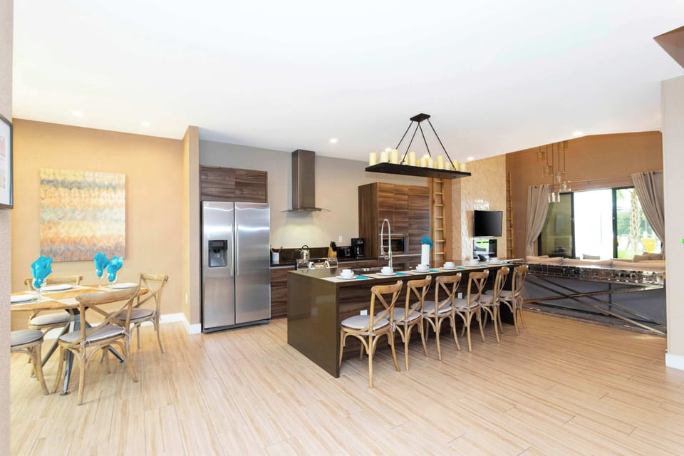 Spacious open-concept kitchen and lounge with stainless appliances, a long island with plenty of seating, and a foosball table-modern and perfect for gatherings.