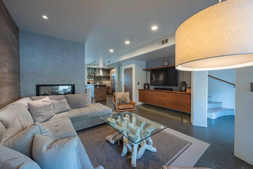 Living room has a large TV and fireplace which separates the living room and dining room