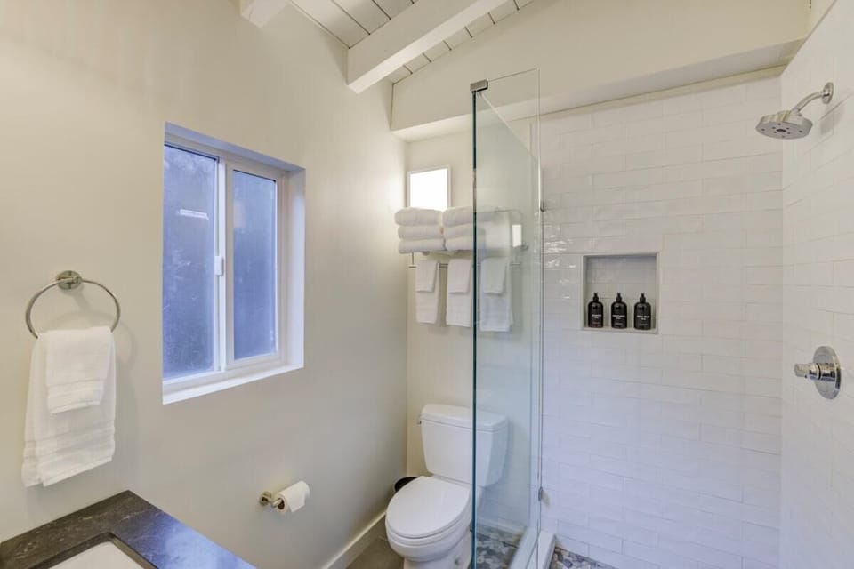 En-suite bathroom with rain shower and Public Goods toiletries.