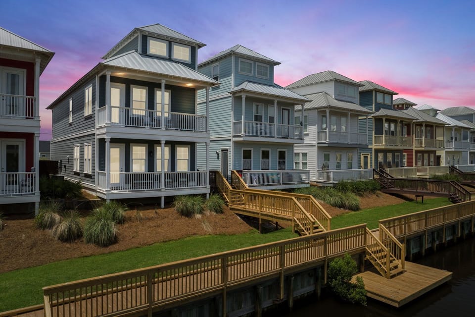 Back view with boardwalk to the pool and small boat dock.