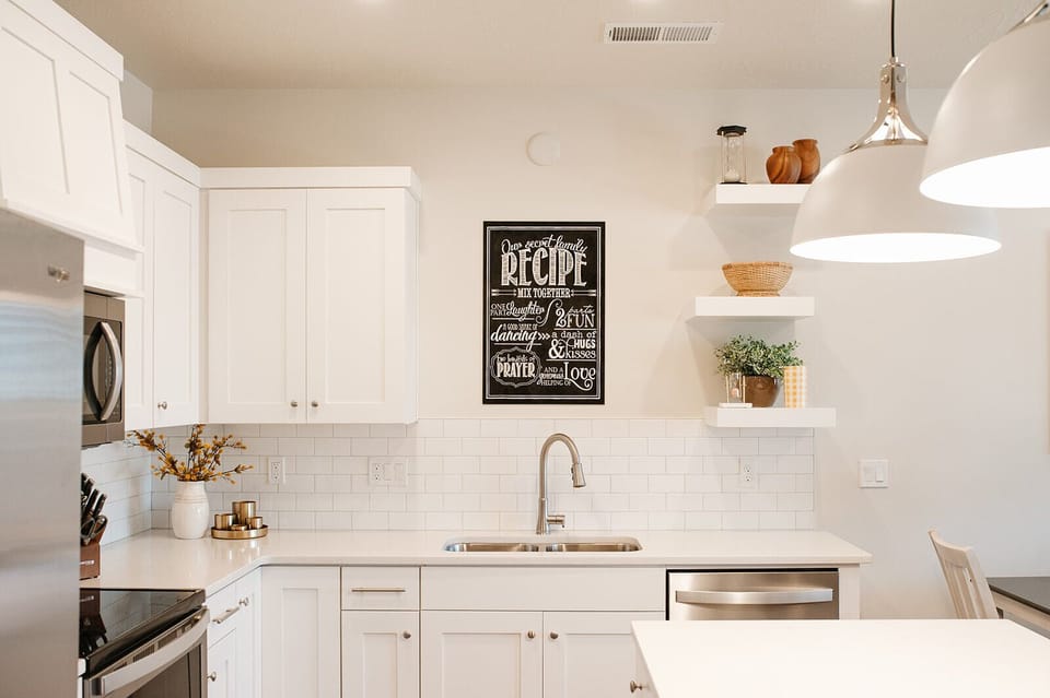 Cook and connect in the modern kitchen with stainless steel appliances, large island seating, and open layout — ideal for family stays near St. George.