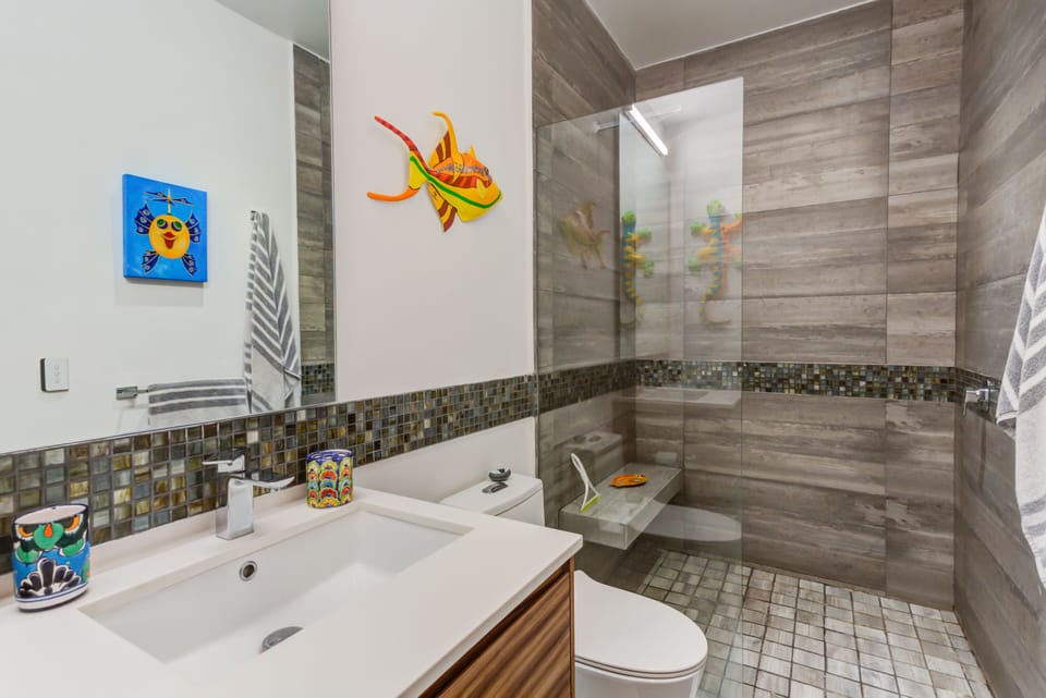 This beautifully appointed guest bathroom provides a clean, refreshing space with high-end finishes and playful marine decor to elevate your morning routine.
