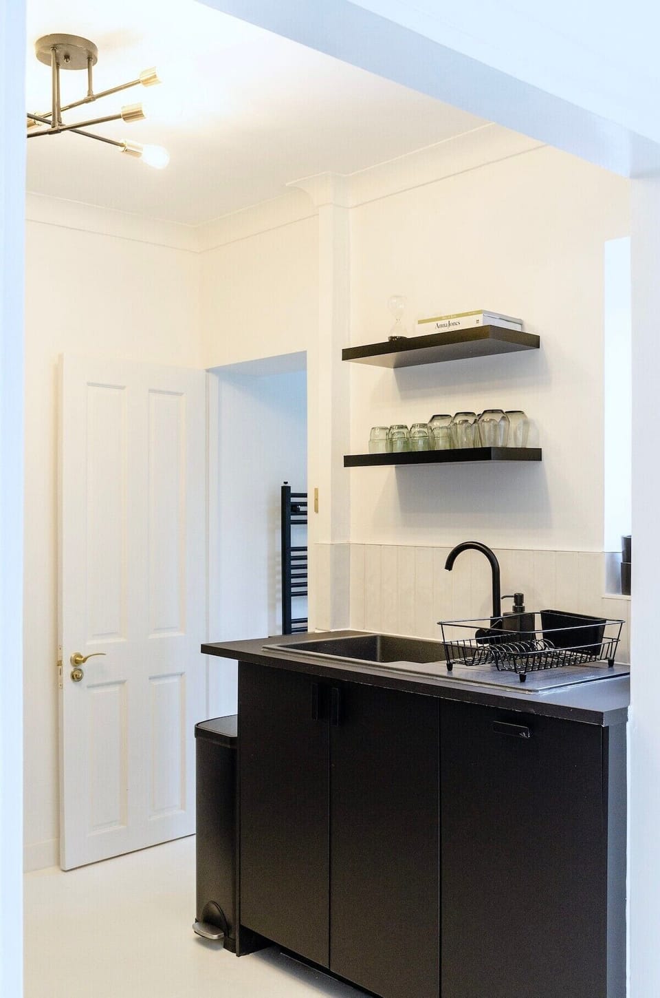 Enjoy our functional and stylish kitchen space with a sink and a convenient shelf above it