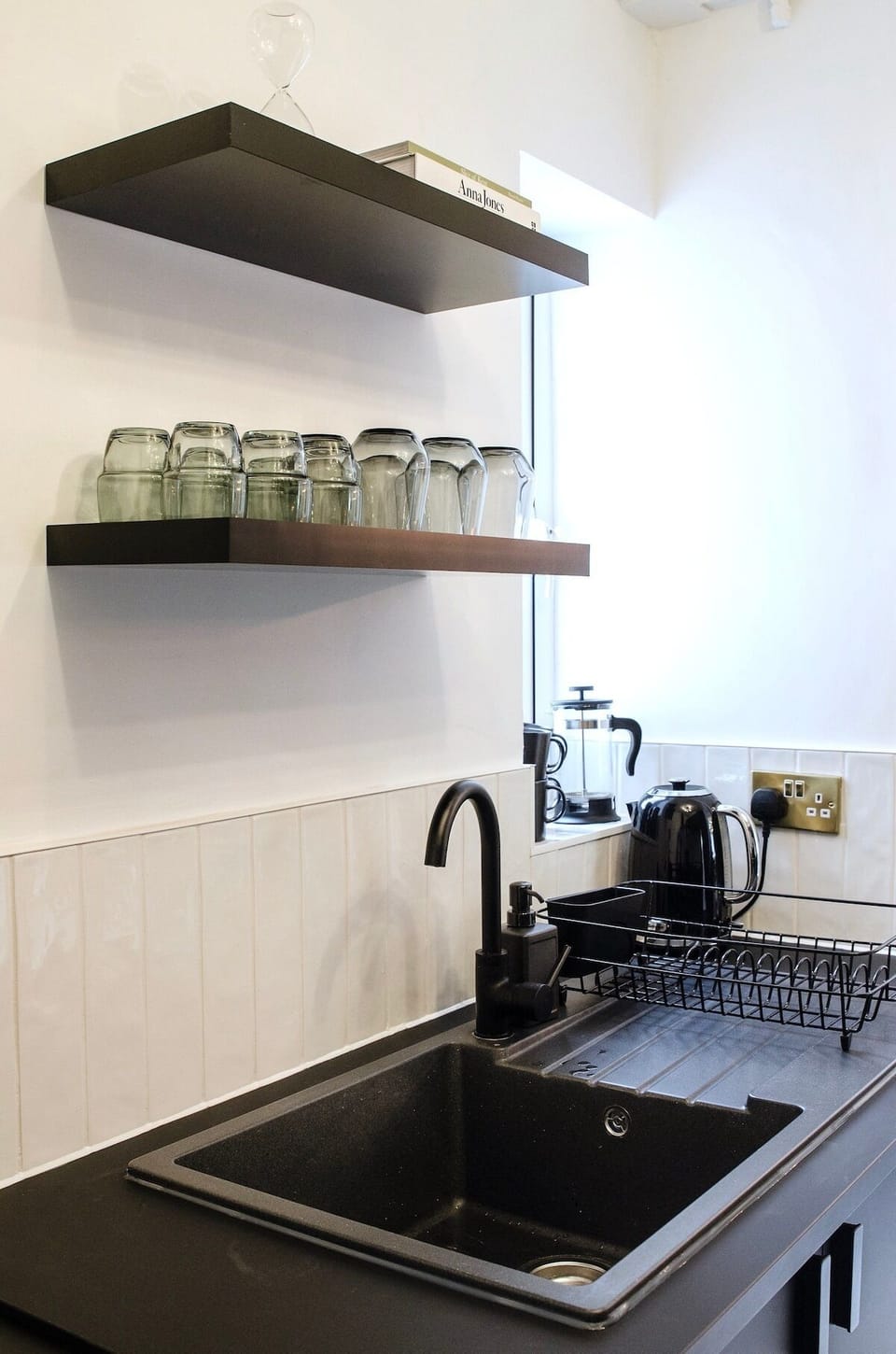 Feast your eyes on this breathtaking kitchen with a practical sink and trendy shelves above