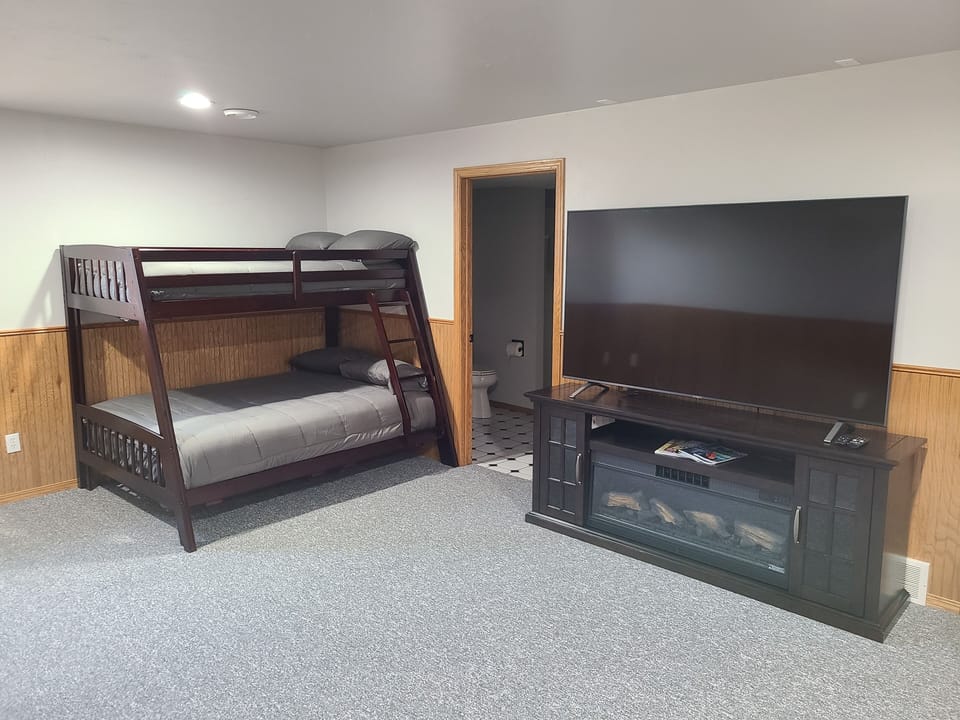 Bunk beds and 75 inch TV in lower level.  Door to full bath.