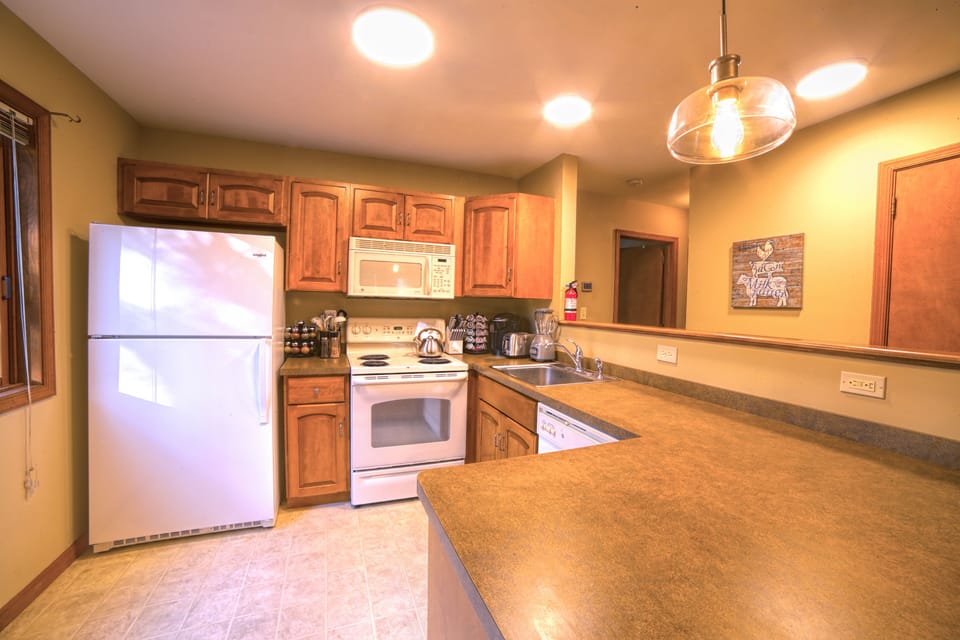Well equipped kitchen with peninsula with 3 stools.