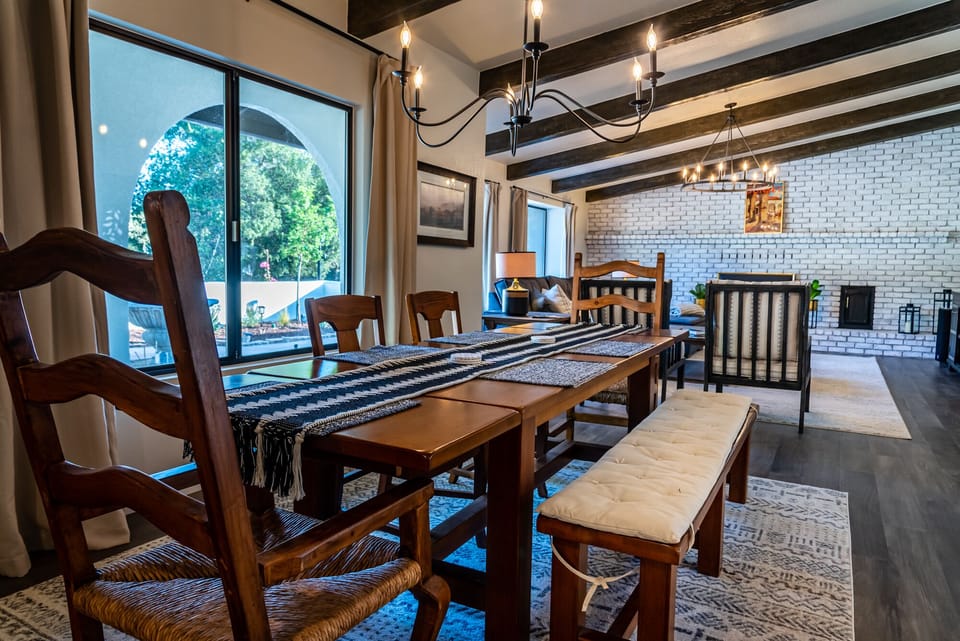 Dining area opening to the kitchen with a sculptural chandelier