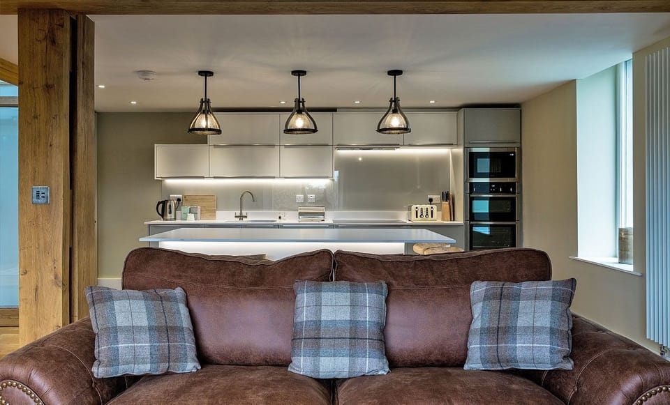 The sofa and kitchen at The Old Grain Store, Lake District