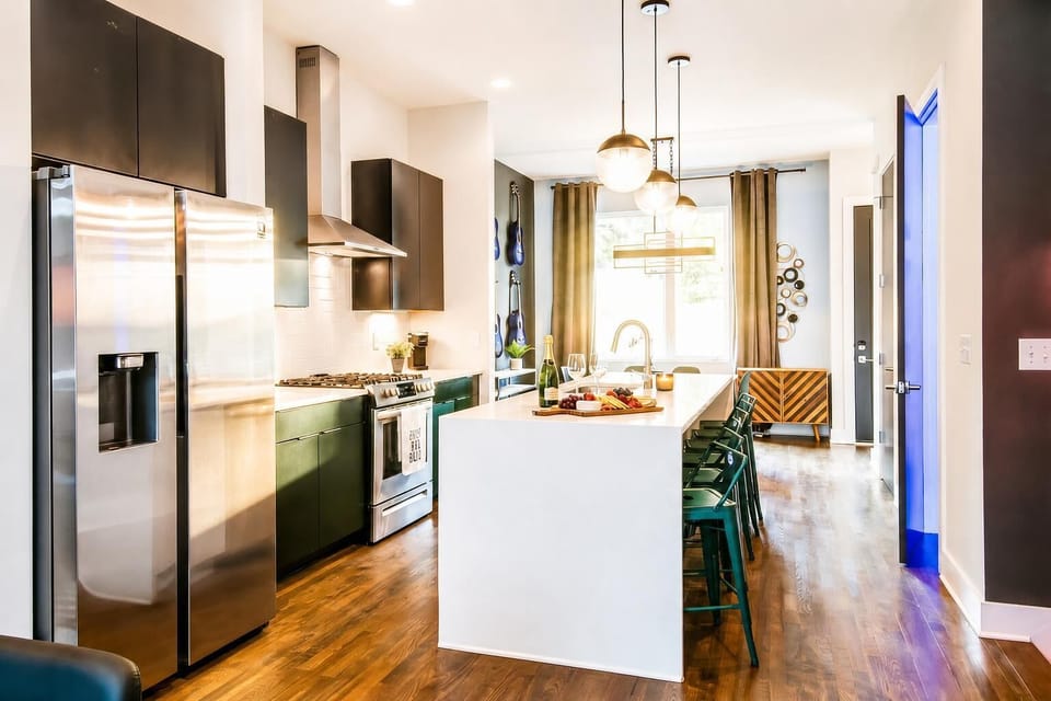 The open kitchen centers on an island where the cook stays connected to the group while you're prepping snacks and mixing drinks. Stainless appliances and bar seating make gatherings happen naturally