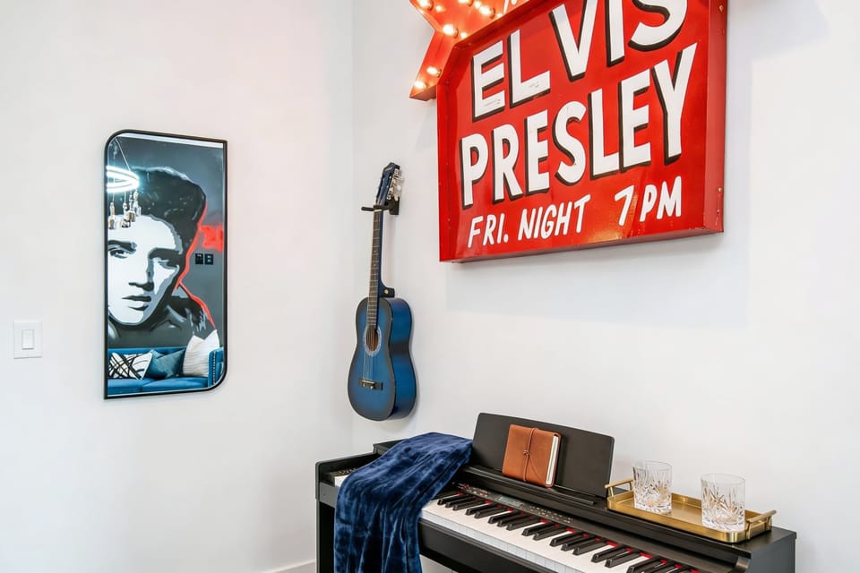 The dedicated music room with a grand piano, blue acoustic guitar, and 'Elvis Presley' marquee gives the theme its own quiet corner. A moment to breathe between karaoke rounds