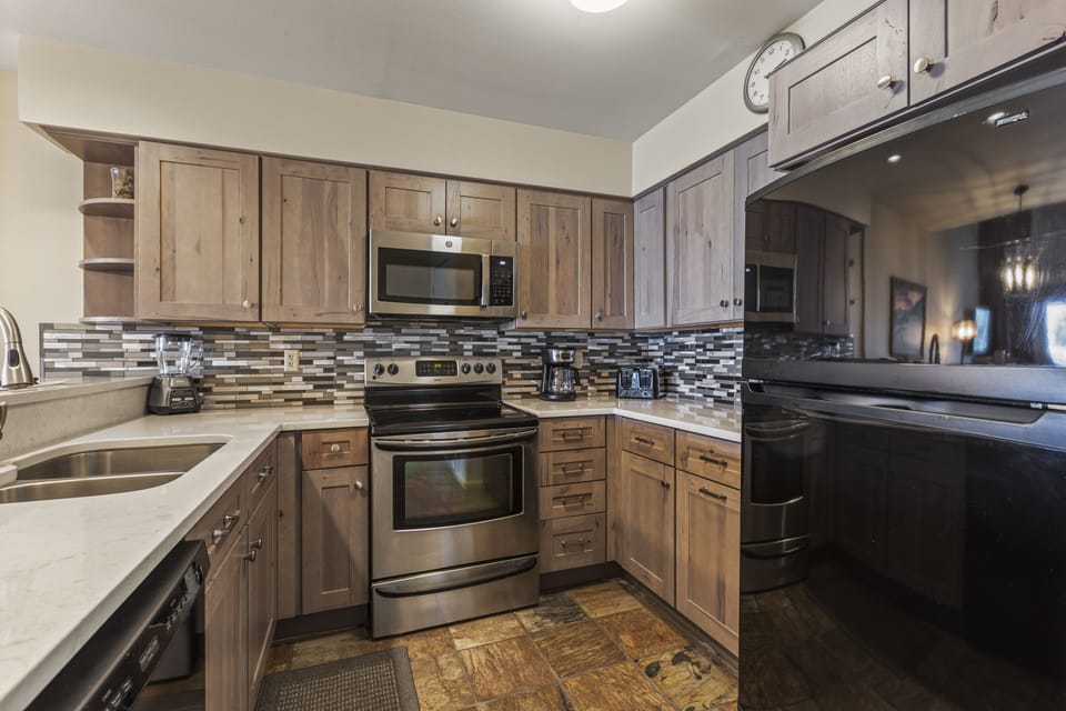 Snow Flower 127 has a well-equipped kitchen with wood cabinets and black and stainless steel appliances.