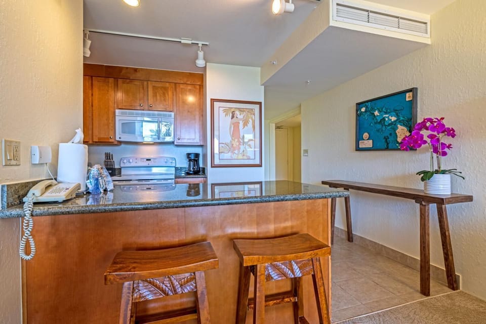 Tropical touches and warm wood cabinets invite you to sip, sauté, and savor island flavors under golden island light    