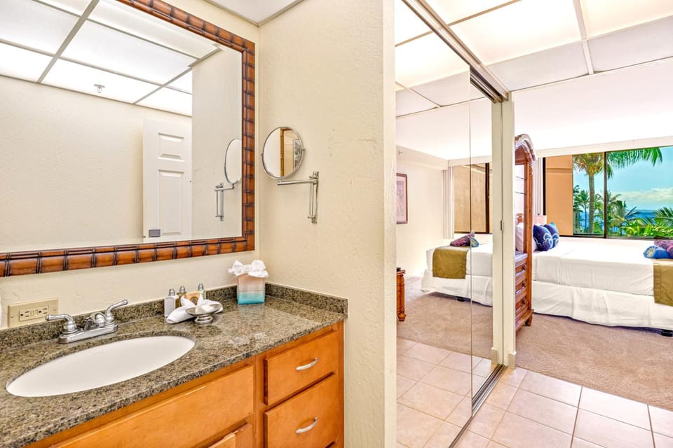 Soft lighting and a view into the suite beyond connect bedroom and bath, inviting a seamless flow of light and tranquility    