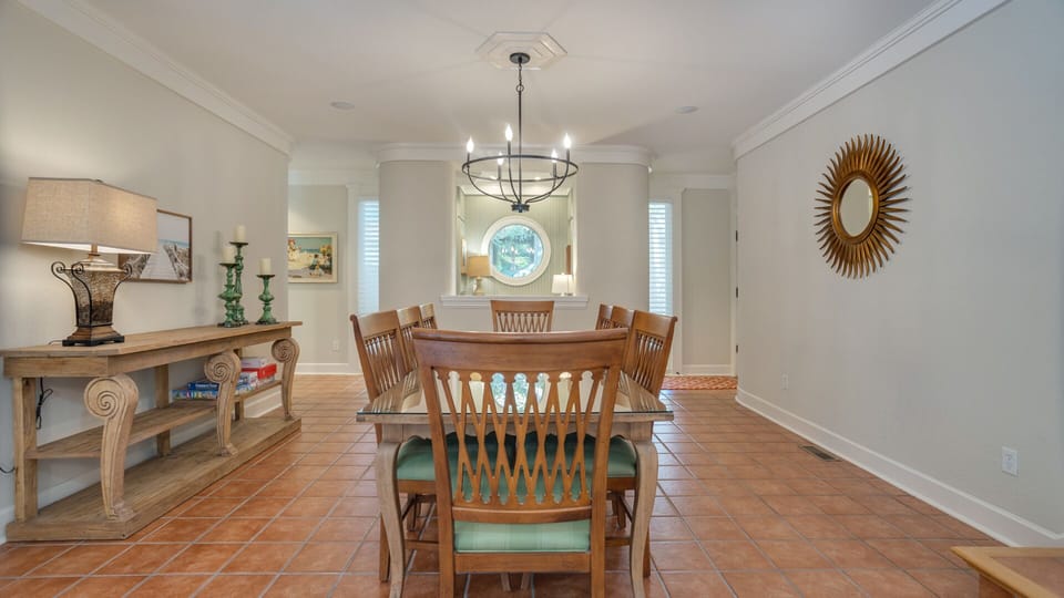 Warm terracotta tile flooring adds character and durability, while the elegant chandelier provides a stylish focal point.