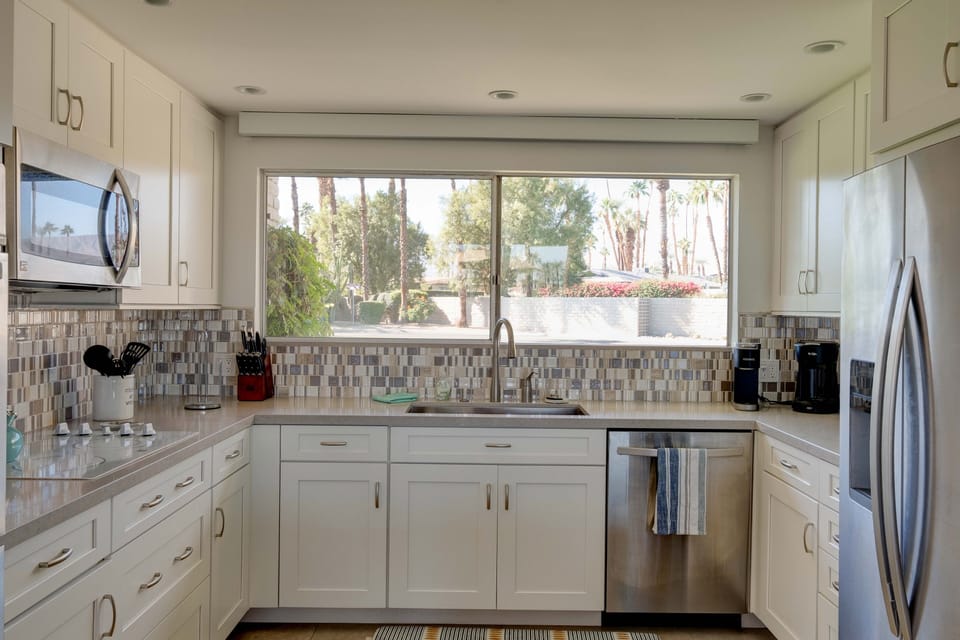 large kitchen area, large farm house stainless steel sink and granite counters