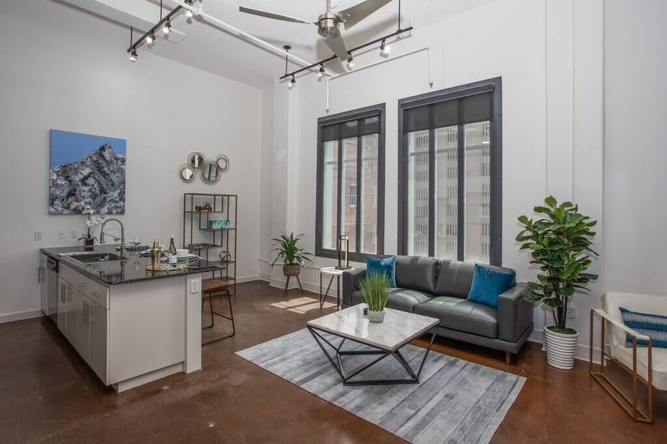 Relax in this cozy, modern living room featuring chic décor, comfortable seating, and warm lighting that creates the perfect ambiance for unwinding in the heart of downtown Fort Worth.