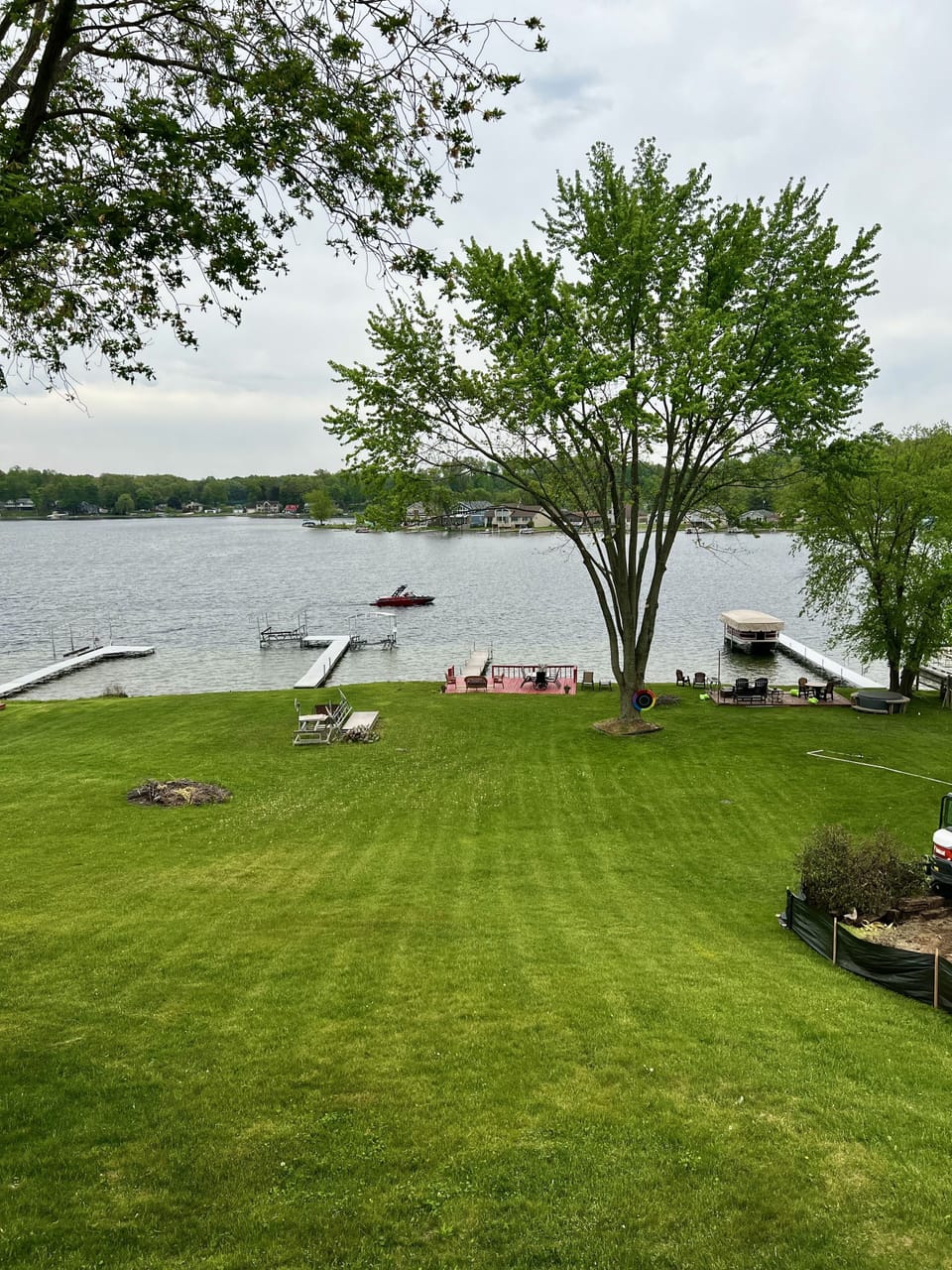 Sandy water front with deck, fire pit, pier, and swim platform.