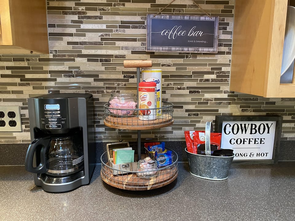 The coffee bar is equipped with a coffee maker, coffee, cocoa, and an assortment of teas.