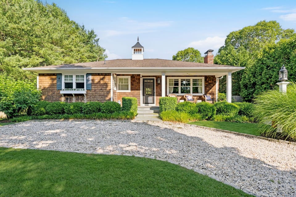Cedar-shake cottage with cupola and covered porch