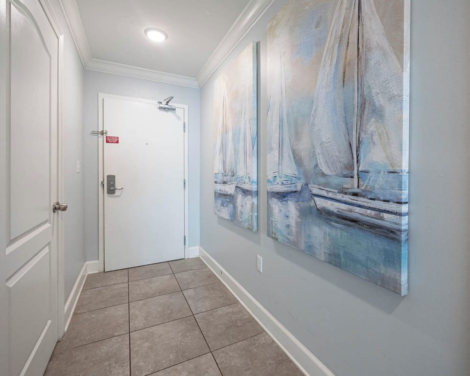 Step into a welcoming entryway adorned with nautical art, setting a relaxed tone for your beach getaway