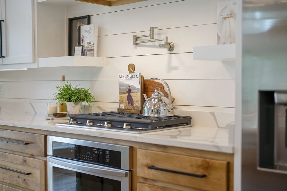 Cook like a pro with this premium 5-burner gas cooktop, set against a chic white shiplap backsplash. The perfect setup for preparing gourmet meals in a modern yet cozy kitchen.