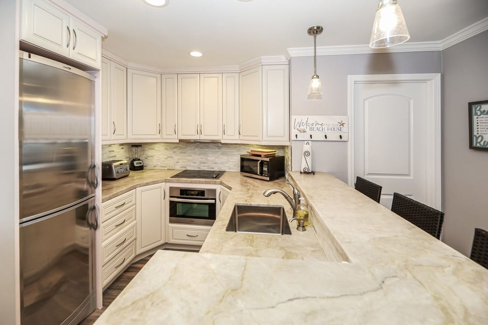 Beautiful updated kitchen with stone countertops and stainless steel appliances.