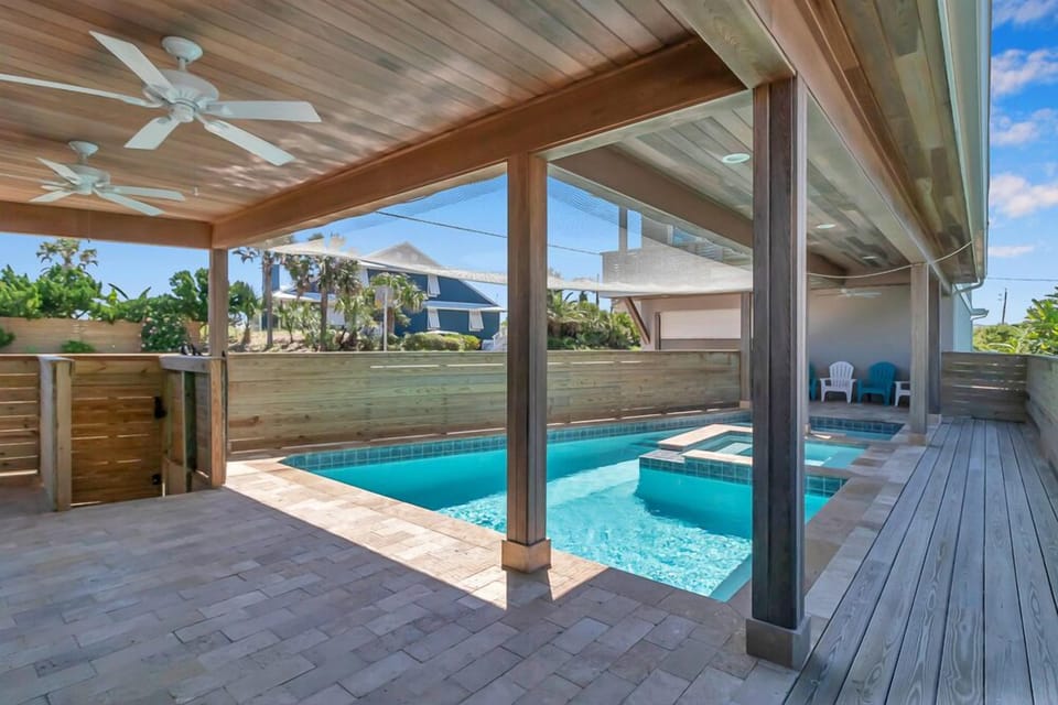 - Dip into the shaded pool area complete with ceiling fans, spa, and tropical ambiance
- Wide deck and overhead cover let you enjoy the water comfortably all day
- Lounge chairs and privacy fencing create your personal beachside oasis