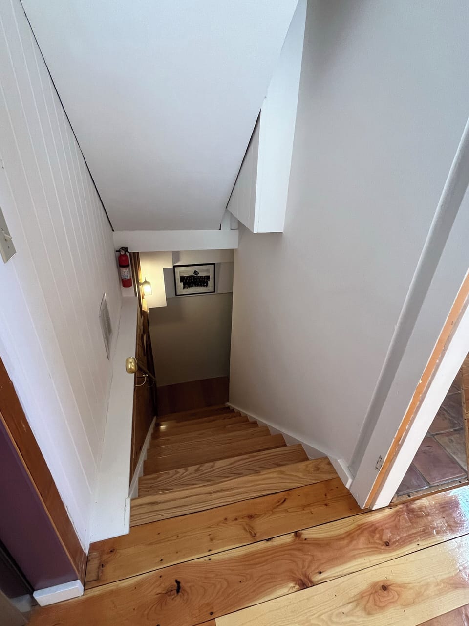 Polished wood stairs guide your way to cozy spaces below, with warm lighting welcoming you at every turn.