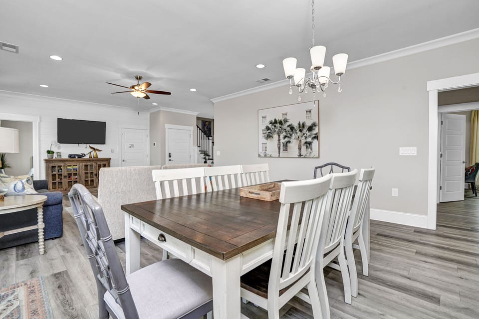 Gather around this spacious dining table where your group can share memorable meals under elegant chandelier lighting.