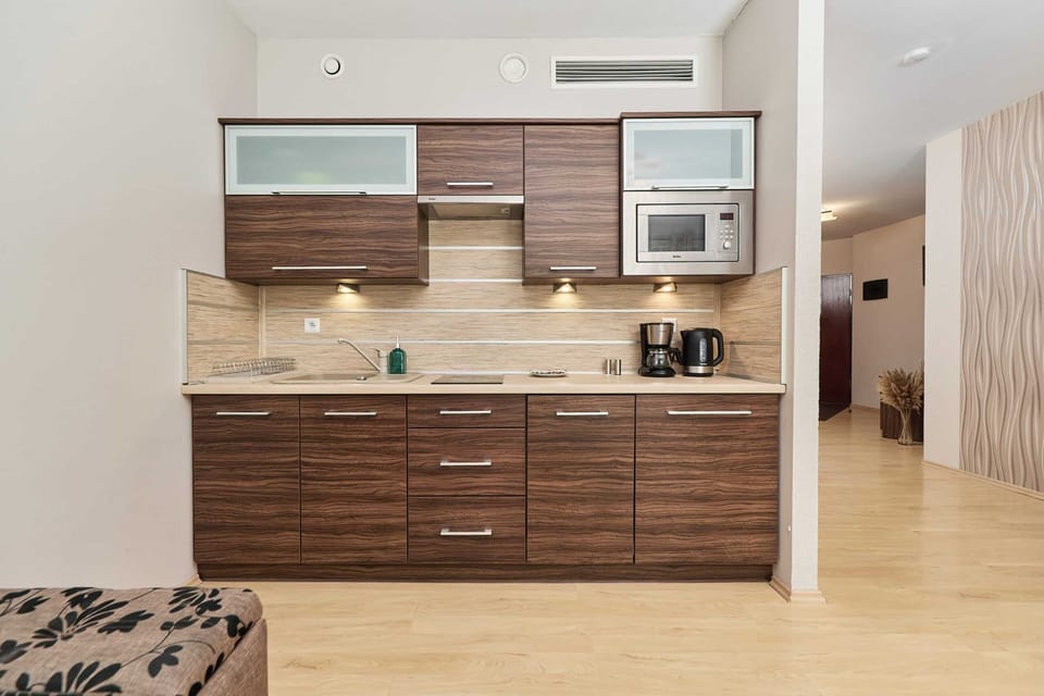 Kitchenette with kettle and refrigerator. 