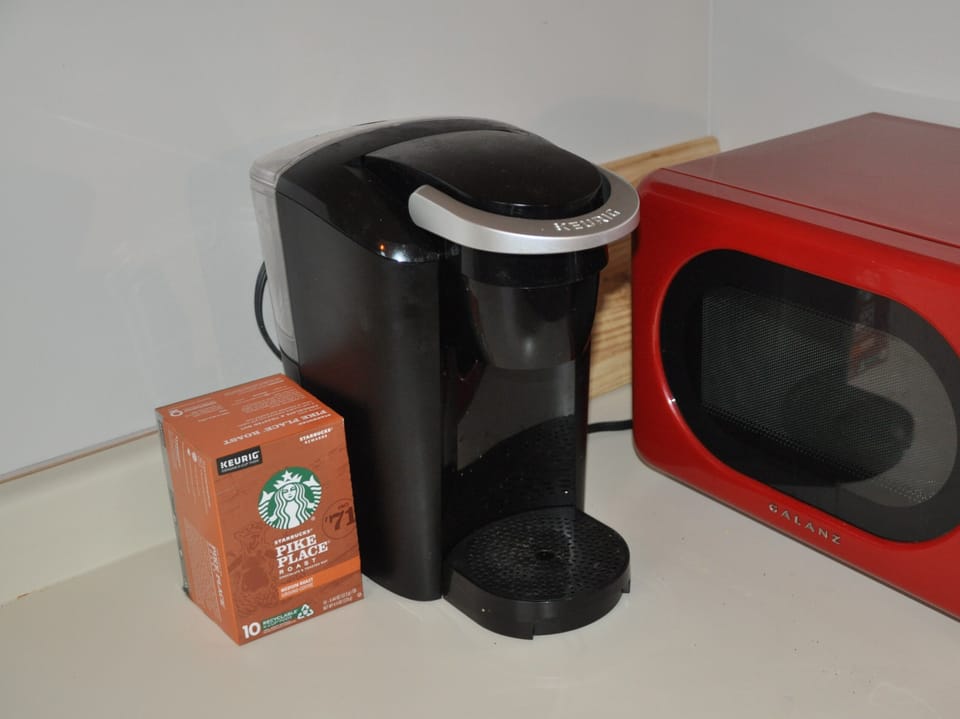 Keurig coffee maker, Starbucks k-cups, and a microwave warm up the morning