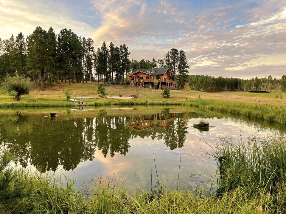 Stunning Log Home on 11 acres. Spring fed pond. Borders USFS on 3 sides 