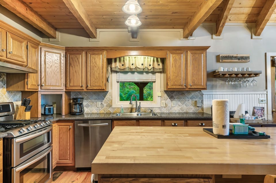 Full kitchen with stainless steel appliances, butcher block island