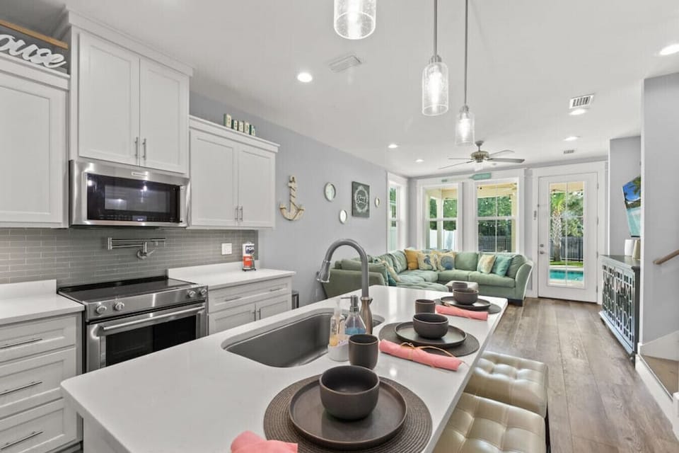 Open fully-stocked kitchen with stainless steel appliances, pot filler, and breakfast bar, located on 1st floor