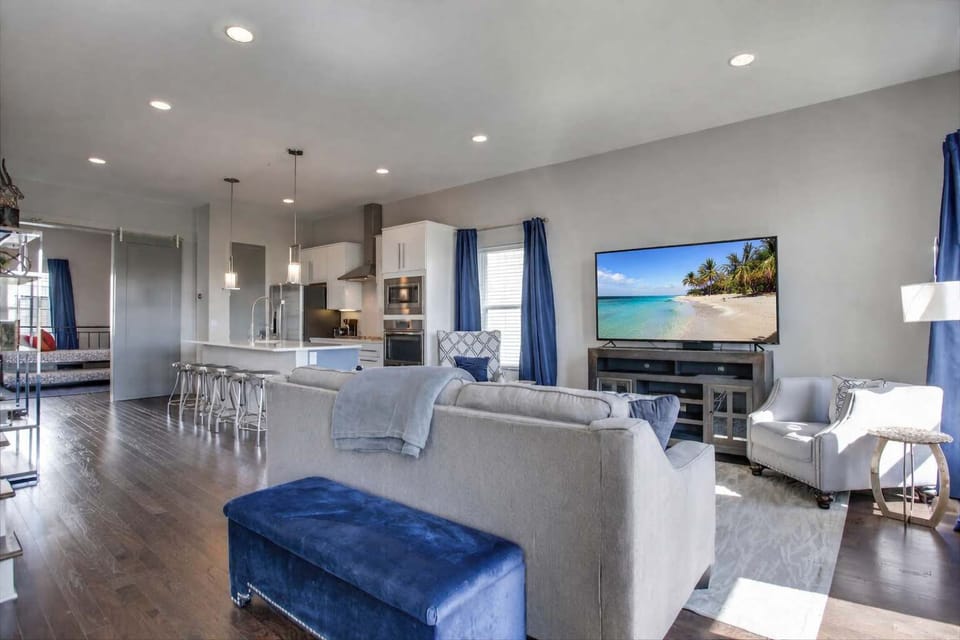Bright open-concept living and kitchen space with calming blue tones, perfect for relaxing and entertaining during your stay.
